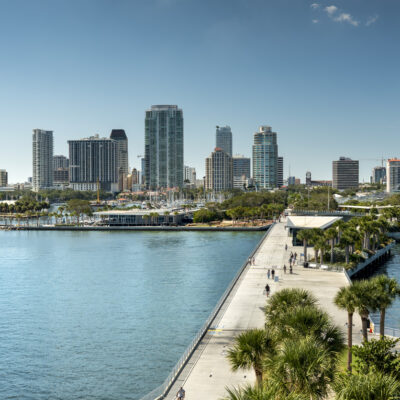 St. Petersburg, Florida USA - November 7 2023: People walk on the St. Petersburg city coastal waterfront St. Pete Pier boardwalk path on Florida's Gulf Coast in the Tampa Bay area. It's known for its pleasant weather and is nicknamed the “Sunshine City”